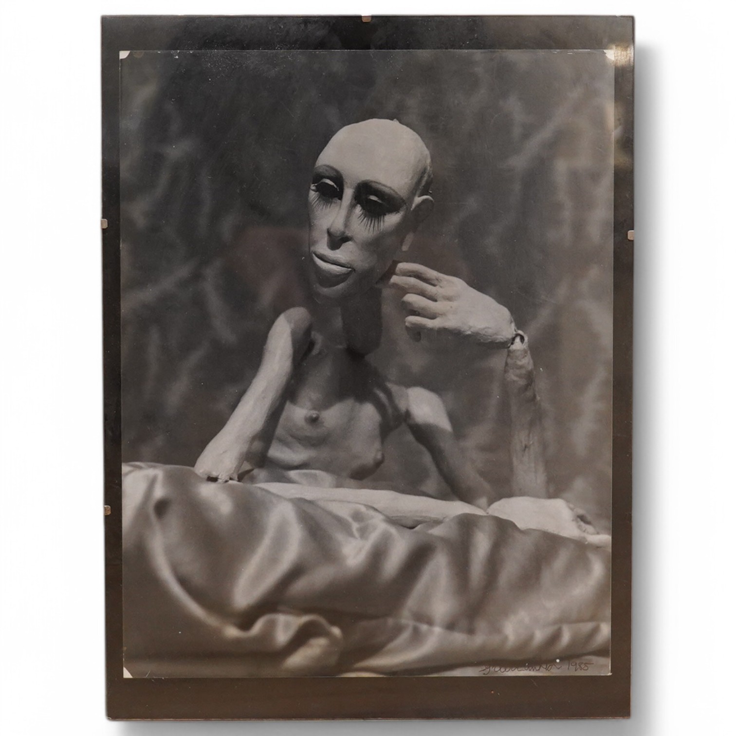 A black and white New York artscene photograph - seated marionette, indistinctly signed, dated 1985, 35.5 x 27.5cm. Condition - fair.